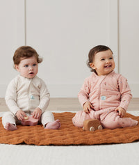 Two infants sitting in ergoPouch Sleep Onesie 2.5 TOG Daisies and Oatmeal Marle, warm for the winter