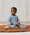 Child sitting in an ergoPouch Sleep Onesie 3.5 TOG Dragonflies, an extra warm pouch