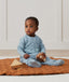 Child sitting in ergoPouch Sleep Onesie 2.5 TOG Dragonflies, warm for the winter