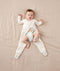 Child being dressed into an ergoPouch Sleep Onesie 2.5 TOG Oatmeal Marle