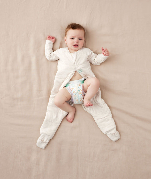 Child being dressed into an ergoPouch Sleep Onesie 2.5 TOG Oatmeal Marle
