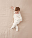 Child lying in an ergoPouch Sleep Onesie 2.5 TOG Oatmeal Marle