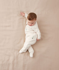 Child lying in an ergoPouch Sleep Onesie 2.5 TOG Oatmeal Marle