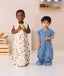 Two toddlers smiling at the camera wearing ergoPouch Jersey Sleep Suit Sack 0.2 TOG in Petit Pretzel and Bon Appetit