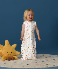 Smiling toddler wearing an ergoPouch Jersey Sleep Suit Sack  0.2 TOG Daydream, a sleeping sack that converts to a sleep suit with legs