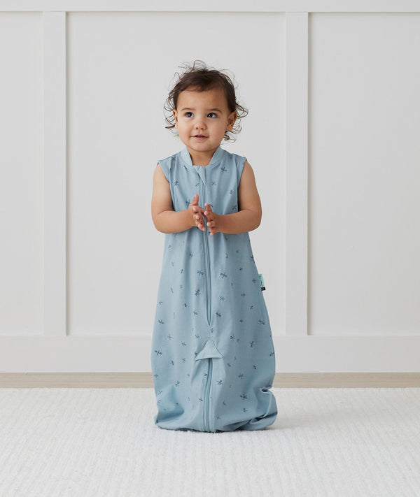 Child standing in ergoPouch Jersey Sleep Suit Sack 0.2 TOG Dragonflies, a light sleeping bag that converts to a sleeping bag with legs