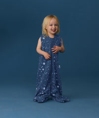 Smiling toddler wearing an ergoPouch Jersey Sleep Suit Sack 0.2 TOG Starbeam, a sleep sack that converts to a sleep suit with legs.