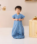 Toddler standing wearing ergoPouch Sleep Suit Sack 1.0 TOG in Petit Pretzel