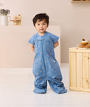 Toddler standing looking at the camera wearing Product shot of ergoPouch Sleep Suit Sack 1.0 TOG in Petit Pretzel