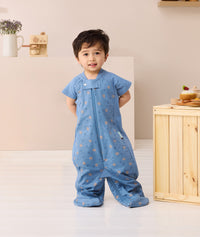 Toddler standing looking at the camera wearing Product shot of ergoPouch Sleep Suit Sack 1.0 TOG in Petit Pretzel