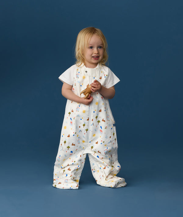 Toddler wearing an ergoPouch Sleep Suit Sack 1.0 TOG Daydream, a sleep sack that converts to a sleep suit with legs by a four-way zipper feature. 