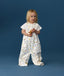 Toddler wearing an ergoPouch Sleep Suit Sack 1.0 TOG Daydream, a sleep sack that converts to a sleep suit with legs by a four-way zipper feature. 