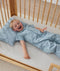 Toddler lying in crib on a ergoPouch Organic Toddler Pillow And Case Dragonflies, designed to support the correct alignment of the neck during sleep