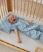 Toddler lying in crib on a ergoPouch Organic Toddler Pillow And Case Dragonflies, designed to support the correct alignment of the neck during sleep