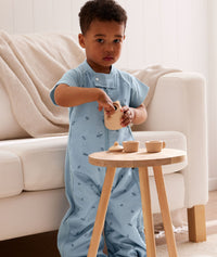 Toddler playing in an ergoPouch Sleep Suit Sack 1.0 TOG Dragonflies, a sleeping bag that converts to a sleeping bag with legs