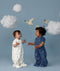 Two children wearing ergoPouch Sleep Suit Sack 1.0 TOG Daydream and Starbeam, a sleep sack that converts to a sleep suit with legs by a four-way zipper feature. 