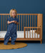 Toddler wearing an ergoPouch Sleep Suit Sack 1.0 TOG Starbeam, a sleeping bag that converts to a sleep suit with legs.