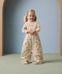 A toddler is standing, dressed in ergoPouch Sleep Suit Sack 2.5 TOG Savannah
