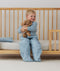 Toddler sitting on bed made with ergoPouch Organic Toddler Pillow And Case Dragonflies