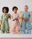 Three children standing in an ergoPouch Sleep Suit Sack 2.5 TOG Willow, Daisies and Dragonflies, a warm sleeping bag that converts to a sleeping bag with legs