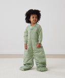 Child standing in an ergoPouch Sleep Suit Sack 3.5 TOG Willow, a warm sleeping bag that converts to a sleeping bag with legs