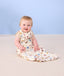 Infant baby sitting on the floor smiling wearing ergoPouch Sleep Sack 0.2 TOG in Bon Appetit