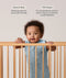 Infant wearing a sleeveless, light blue dragonfly-patterned sleep sack stands in a wooden crib, holding onto the top rail with both hands. Above the baby, text features highlights for the product: Wash & Wear and TOG-Rated.