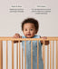 Infant wearing a sleeveless, light blue dragonfly-patterned sleep sack stands in a wooden crib, holding onto the top rail with both hands. Above the baby, text features highlights for the product: Wash & Wear and TOG-Rated.