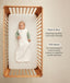 Infant wearing a sleeveless Sleep Sack lying inside a wooden crib with text highlighting wash & wear and TOG rating features.
