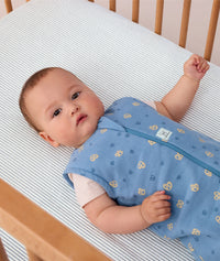 Baby lying in a crib wearing ergoPouch Sleep Sack 0.2 TOG in Petit Pretzel