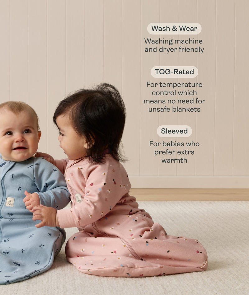 Two babies wearing long-sleeved sleep sack sit on a carpet. Next to them, text highlights features including 