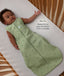 Infant lying in a wooden crib wearing sleeveless Sleep Sack 1.0 TOG Willow with text highlighting slim-fit design for an easy transition from swaddling.