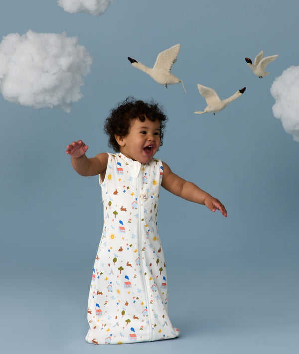 Infant in a cool ergoPouch Sleep Sack 1.0 TOG Daydream with birds and clouds in the background, perfect for everyday