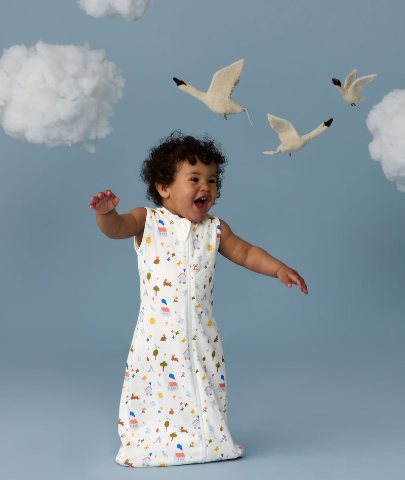Infant in a cool ergoPouch Sleep Sack 1.0 TOG Daydream with birds and clouds in the background, perfect for everyday