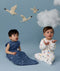 Two infants sitting in ergoPouch sleepwear, one in a Sleep Sack 1.0 TOG Starbeam, the other in a Long Sleeve Romper 1.0 TOG Daydream.
