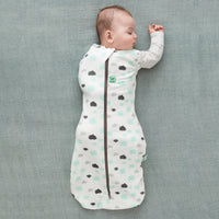 Baby wearing a Cocoon Swaddle Sack with its one arm out.