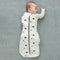 Baby wearing a Cocoon Swaddle Sack with its one arm out.