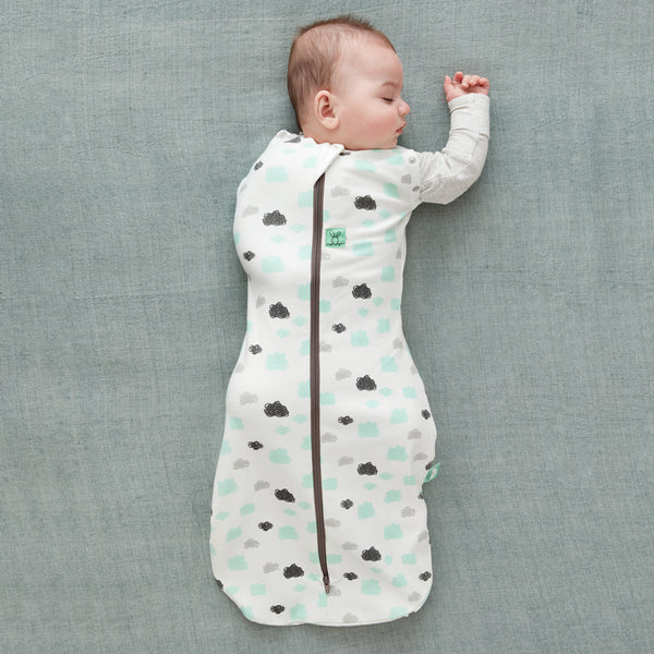 Baby wearing a Cocoon Swaddle Sack with its one arm out.
