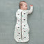 Baby wearing a Cocoon Swaddle Sack with its one arm out.