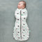 Baby is wearing an ergoPouch Cocoon Swaddle Sack 0.2 TOG Clouds