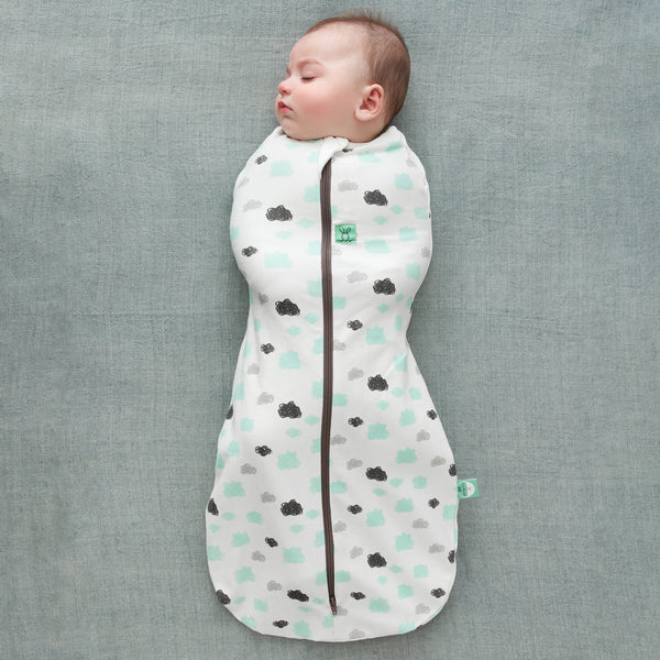 Baby is wearing an ergoPouch Cocoon Swaddle Sack 0.2 TOG Clouds