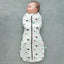Baby is wearing an ergoPouch Cocoon Swaddle Sack 0.2 TOG Clouds