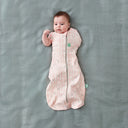 Baby wearing a Cocoon Swaddle Sack Spring Leaves with its one arm out