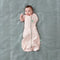 Baby wearing a Cocoon Swaddle Sack Spring Leaves with its one arm out