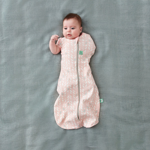 Baby wearing a Cocoon Swaddle Sack Spring Leaves with its one arm out
