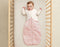 Baby in ergoPouch cocoon swaddle paired with an arm warmer for comfortable sleep.