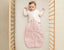 Baby in ergoPouch cocoon swaddle paired with an arm warmer for comfortable sleep.