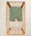 Baby in a crib under an ergoPouch HugMe Blanket in Daisy Sprinkle