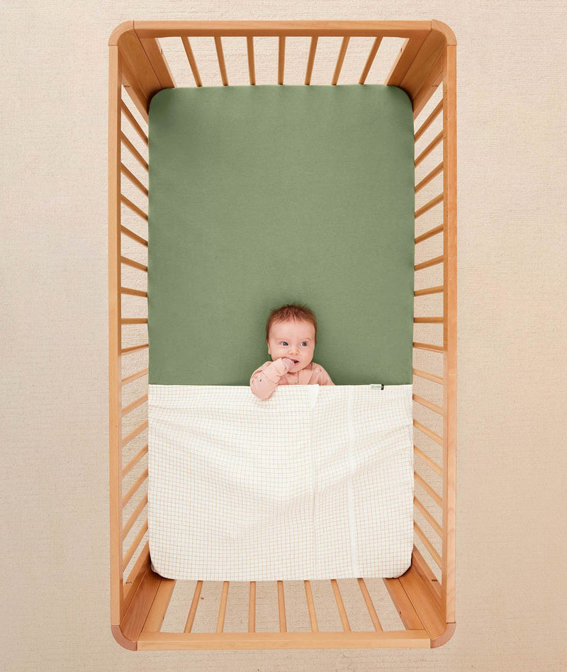 Baby tucked in a ergoPouch HugMe Blanket in Caramel Grid