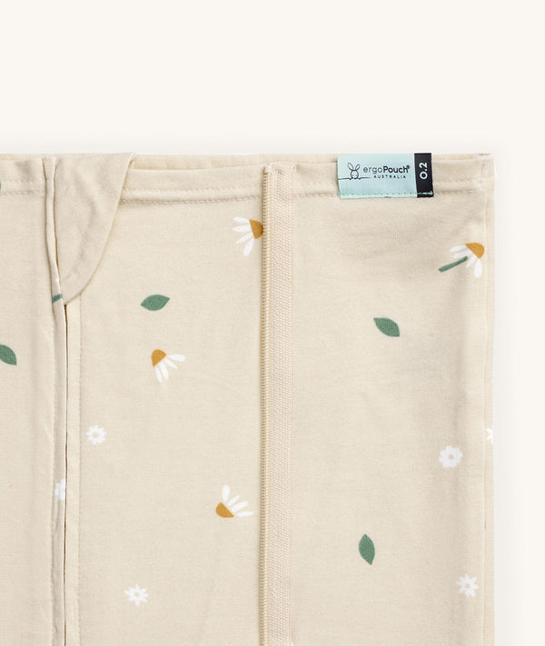 Close-up of a Newborn baby asleep in a bassinet under an ergoPouch HugMe Blanket 0.2 & 1.0 TOG in Daisy Sprinkle displaying the 0.2 TOG side